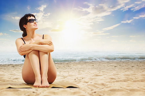 kobieta na plaży korzysta z kąpieli słonecznej